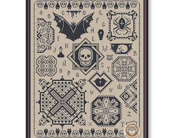 May include: Framed cross-stitch sampler with a Halloween theme. The design features a bat, spider, skull, and other spooky motifs in black on a tan background. The sampler is enclosed in a dark brown frame.