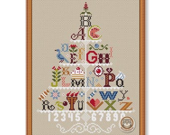 May include: A cross-stitch pattern in a wooden frame featuring the alphabet arranged in a tiered tree shape. Each letter is accompanied by small colorful icons like a watermelon, bird, flower, and cupcake. The numbers 0 through 9 are stitched in white at the bottom.