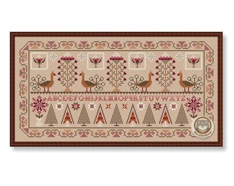 May include: A framed cross-stitch sampler with a beige background and a brown border. The design features stylized trees, peacocks, flowers, and the alphabet in burgundy and brown. The overall theme is a folk art style.