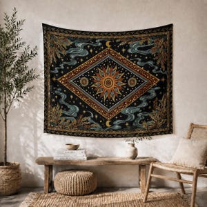 Puede incluir: Un tapiz de pared rectangular con fondo negro y un motivo central de diamante que contiene un sol grande, soles más pequeños y estrellas. El diseño incluye patrones de humo azul, follaje dorado y lunas crecientes.