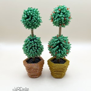 Könnte beinhalten: Zwei Miniatur-Topiary-Bäume in Töpfen. Die Bäume bestehen aus grünen Perlen und haben orangefarbene Perlen als Akzente. Die Töpfe bestehen aus braunen und gelben Perlen.