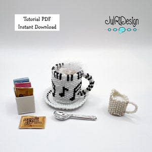 May include: A white and black beaded coffee cup with a musical note design, a white beaded saucer, a white beaded creamer, a silver spoon, and a package of sugar packets. The text "Sugar in the Raw" is on the sugar packet.