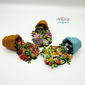May include: Three beaded brooches shaped like tipped flower pots, each spilling a cascade of colorful glass beads in floral patterns. The pots are brown and light blue, with the text JulRiDesign visible in the upper right corner.