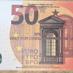 Puede incluir: Una réplica de billete de cincuenta euros en tonos naranja y amarillo, con una ilustración arquitectónica central y el texto "ONLY FOR CINEMA AND THEATRE USE" impreso en el centro. El billete incluye el número 50 y las estrellas de la UE.