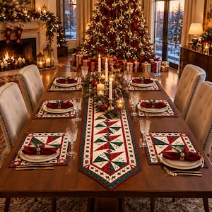 May include: A wooden dining table set for four with a quilted table runner and matching placemats featuring a red, green, and white geometric pattern. Each place setting includes a white plate, a red napkin with a ring, and a crystal glass.