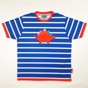 May include: Blue and white striped t-shirt featuring a red dinosaur applique. The shirt has a red collar and sleeve trim. The text "KID CORE" is visible on the collar. A colourful and fun design for children.