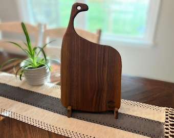 Charcuterie-Brett aus schwarzer Walnuss mit einer tiefen schokoladenbraunen Maserung und einer auffälligen, fließenden Form.