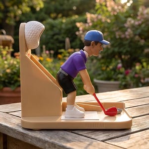 Puede incluir: Un abridor de botellas de plástico beige con temática de golf que presenta una figura de un golfista con gorra azul, camiseta morada y pantalones cortos negros. El golfista sostiene un palo rojo sobre una chapa metálica, con una bola de golf blanca.