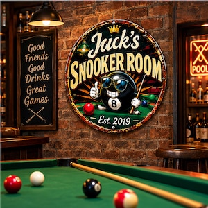 May include: A circular metal sign featuring the text Jack's SNOOKER ROOM and Est. 2019. The graphic depicts a black 8-ball character wearing sunglasses, giving a thumbs up, and holding a pool cue on a green table with red and blue balls.