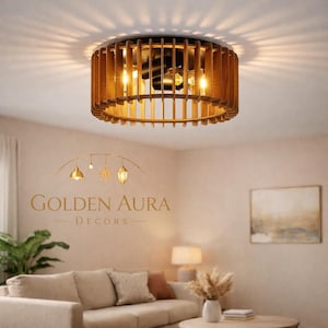May include: A wooden ceiling light fixture with a cylindrical design. The light has a series of vertical wooden slats around the perimeter, with exposed light bulbs inside. The fixture is mounted on a white ceiling. The text "GOLDEN AURA DECORS" is visible.