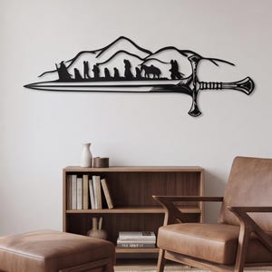 May include: A black metal wall art piece featuring a silhouette of a group of travelers walking across a mountain range, integrated into the design of a long, pointed sword. The artwork displays a detailed hilt and a sharp, elongated blade.