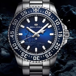 Può includere: Un orologio da polso in acciaio inossidabile con quadrante blu e lunetta girevole. Il quadrante presenta indici e lancette bianche, con la scritta "SEA-GULL" e l'immagine di una portaerei. L'orologio ha un cinturino in metallo.