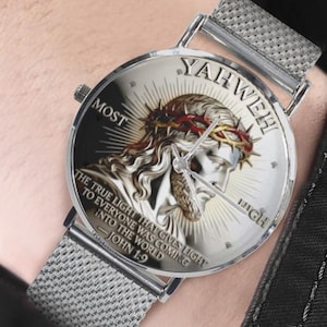 May include: A silver wristwatch with a mesh band. The watch face features an image of Jesus wearing a crown of thorns, with the words "MOST HIGH" and "YAHWEH" around the image. The text "THE TRUE LIGHT THAT GIVES LIGHT TO EVERYONE WAS COMING INTO THE WORLD JOHN 1:9" is also visible.