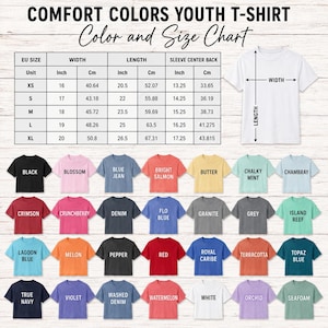 Puede incluir: Una tabla de colores y tallas de camisetas juveniles Comfort Colors con medidas en pulgadas y cent&iacute;metros, un diagrama de camiseta blanca y una cuadr&iacute;cula de veintiocho iconos de camisetas de colores con sus nombres.