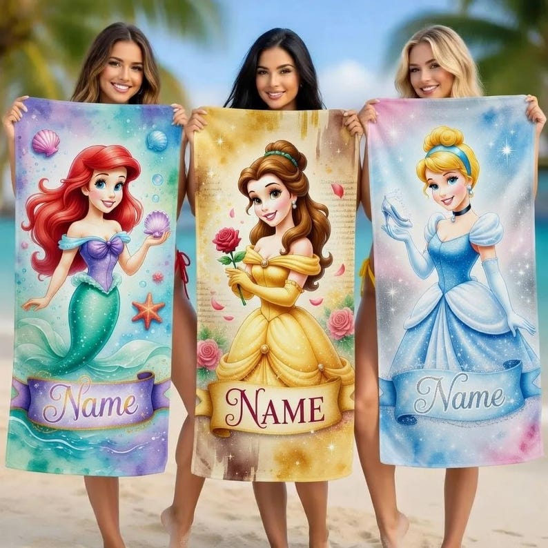 May include: Three beach towels featuring Disney princesses: Ariel, Belle, and Cinderella. Each towel has a princess illustration, a banner with the word "Name", and a colorful background. The towels are held up by three people on a beach.