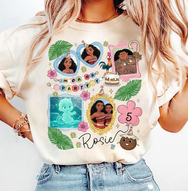 Puede incluir: Una camiseta de color crema con un estampado gr&aacute;fico colorido de personajes de Moana, hojas tropicales, flores de hibisco, un pastel de cumplea&ntilde;os y un globo con el n&uacute;mero 5. El texto "PARTY" y el nombre "Rosie" est&aacute;n impresos en la camiseta.