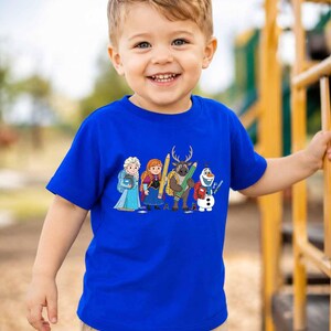 Puede incluir: Una camiseta de manga corta de color azul brillante con un estampado gr&aacute;fico colorido de cuatro personajes animados de la franquicia Frozen, incluidos Elsa, Anna, Sven y Olaf, cada uno sosteniendo &uacute;tiles escolares como l&aacute;pices y libros.