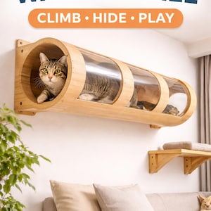 Puede incluir: Un túnel de pared para gatos de madera clara montado horizontalmente, con tres ventanas de visualización de acrílico transparente. Un gato atigrado está dentro. El texto superior dice CAT WALL TUNNEL y CLIMB HIDE PLAY. Hay un estante debajo.