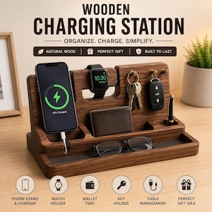 Op de afbeelding: Een houten oplaadstation met vakken voor telefoon, horloge, portemonnee, sleutels en pen. De telefoon wordt opgeladen. De tekst op de afbeelding luidt "WOODEN CHARGING STATION". Ontworpen om te organiseren en te vereenvoudigen. Gemaakt van natuurlijk hout.