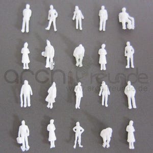 Peut inclure: Une collection de petites figurines blanches pour maquettes architecturales, dans diverses poses : debout, assis et penché. Les figurines sont disposées sur une surface grise. L'image comprend le texte "archifreunde" et une adresse de site web.