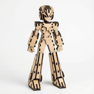 Könnte beinhalten: Eine Holzroboterfigur mit hellbraunem Körper und schwarzen Akzenten. Der Roboter hat ein detailliertes Design mit beweglichen Gelenken, einem Helm und großen Stiefeln. Die Figur steht aufrecht vor einem weißen Hintergrund und zeigt ihre komplizierte Konstruktion.