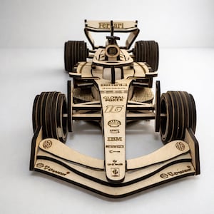 Può includere: Una tazza di ceramica bianca con manico nero e la scritta "But First, Coffee" in grassetto nero. La tazza è su una superficie bianca. La tazza è alta circa 10 cm.