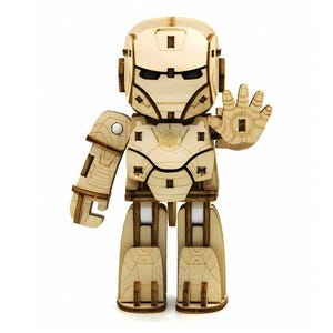 May include: A wooden Iron Man figure, assembled from interlocking pieces. The figure is light brown with darker brown accents, featuring a detailed helmet, chest plate, and articulated limbs. The right hand is raised in a gesture. A fun, creative craft project.