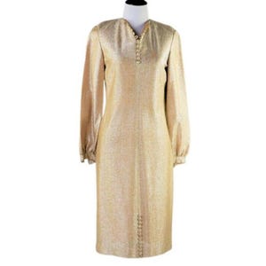 May include: A gold metallic dress with long sleeves and a button-up front. The dress has a fitted silhouette and a slightly flared skirt.