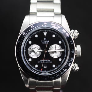 Peut inclure: Une montre chronographe Tudor Geneve en acier inoxydable avec un cadran noir. La montre dispose d'un affichage de la date, de sous-cadrans et d'une échelle tachymétrique. Bracelet en acier inoxydable, certifiée chronomètre.