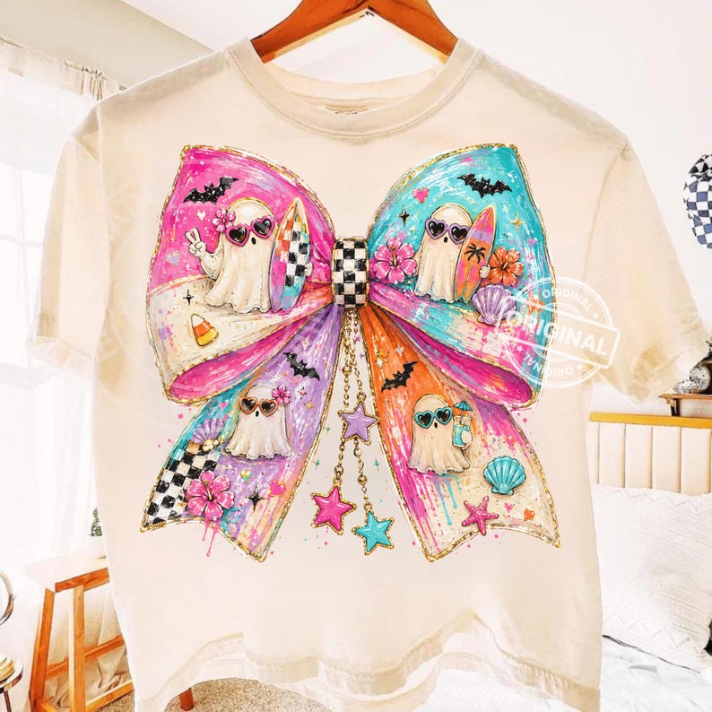 Pu&ograve; includere: T-shirt color crema con un grande disegno a fiocco colorato. Il fiocco presenta personaggi fantasma con occhiali da sole e tavole da surf. Il fiocco ha sezioni rosa, viola e turchese con stelle e conchiglie. La maglietta ha uno scollo tondo.