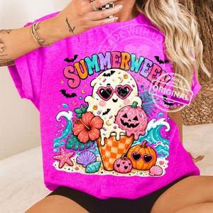 May include: A vibrant pink t-shirt with the word "Summerween" in a colourful graphic. The design includes a ghost with heart-shaped sunglasses, a jack-o'-lantern, an ice cream cone, and beach-themed elements.