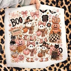 Op de afbeelding: Wit Halloween-thema decoratieve stof met spookkarakters, pompoenen, vleermuizen en bloemaccenten. Tekst bevat "Hey BOO", "Pumpkin Patch" en "Spooky Season but make it cute". Het ontwerp bevat roze en oranje kleuren.