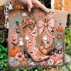 May include: A decorative pillow featuring a whimsical design with two pink and brown cowboy boots adorned with bows, pearls, and leopard print. The boots are surrounded by Halloween and beach-themed elements, including pumpkins, ghosts, and seashells. The word "ORIGINAL" is printed on the bottom.