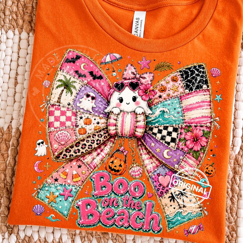 May include: Orange t-shirt with a colorful graphic featuring a ghost wearing sunglasses, a patchwork bow, and the text "Boo on the Beach." The design includes Halloween and beach-themed elements like pumpkins, seashells, and palm trees.