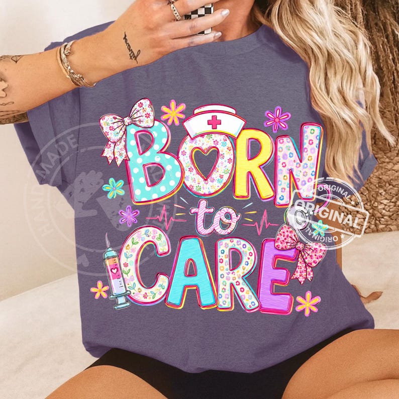 K&ouml;nnte beinhalten: Ein lila T-Shirt mit dem Schriftzug "Born to Care" in bunten, floral dekorierten Buchstaben. Das Design umfasst eine Krankenschwesterm&uuml;tze, eine Spritze und eine Herzschlaglinie mit dekorativen Schleifen und Blumen.