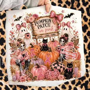 May include: A white decorative pillow featuring a "Pumpkin Patch in Pink" design. The design includes pumpkins, ghosts, black cats, and a skeleton figure. The text "Hope, Love, Cure" is also present.
