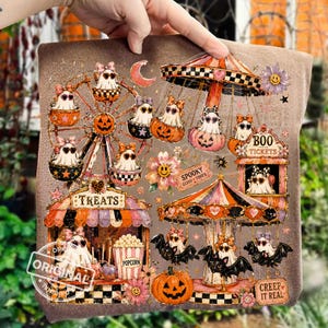 Op de afbeelding: Een Halloween-thema ontwerp met een reuzenrad, een carrousel en carnavalelementen. Het ontwerp bevat geesten, pompoenen, vleermuizen en de tekst "Treats", "Boo Tickets", "Spooky Good Times", "Creep It Real" en "Original".