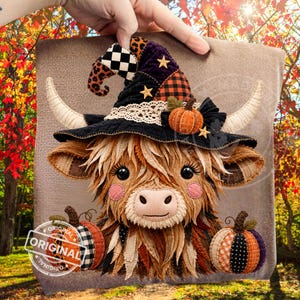 May include: A plush Highland cow decoration featuring a black witch hat with leopard print, checkered patterns, and gold stars. The cow has light brown fur, pink cheeks, and two pumpkins at the base. The design includes lace trim and orange accents.