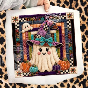 May include: A square fabric wall hanging featuring a central cream-coloured ghost wearing a purple floral witch hat with a teal bow. The ghost is surrounded by orange, teal, and purple pumpkins, set against a colourful patchwork border of stripes.