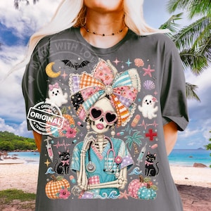 May include: Dark gray t-shirt featuring a skeleton nurse design with a large patchwork bow, heart-shaped sunglasses, and a stethoscope. The shirt includes Halloween and medical-themed graphics, such as pumpkins, ghosts, and a cross. The text "ORIGINAL" is printed on the shirt.