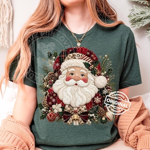 Puede incluir: Una camiseta verde oscuro con un gráfico de Santa Claus con barba blanca, usando un gorro rojo con estampado de leopardo. El diseño incluye ramas de pino, piñas, adornos y un lazo. El texto "ORIGINAL" está impreso en un recuadro blanco.
