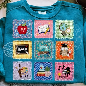 Peut inclure: Sweat-shirt bleu sarcelle orné de neuf écussons carrés sur le thème de l'école. Les écussons comprennent une pomme, un livre ouvert, un globe, un tableau noir avec "TEACH", une machine à coudre, un hibou, une palette de peinture, des livres avec une tasse et un piano.