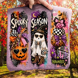 May include: A lavender sweatshirt featuring three vertical panels with Halloween graphics. The first shows a pumpkin with heart-shaped sunglasses and a bow. The second shows a ghost in a witch hat and boots. The third shows stacked pumpkins.