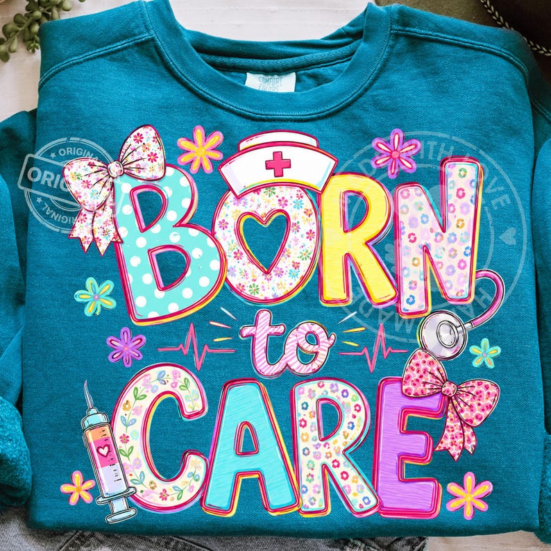 K&ouml;nnte beinhalten: T&uuml;rkisfarbenes Sweatshirt mit dem Schriftzug "BORN to CARE" in bunten, floral gemusterten Buchstaben. Das Design umfasst eine Krankenschwesterm&uuml;tze, ein Stethoskop, eine Spritze und Schleifen. Das Sweatshirt hat einen Rundhalsausschnitt.