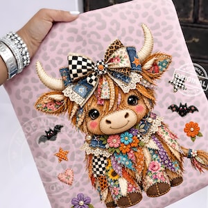 Puede incluir: Una superficie rosa claro con una ilustración impresa de una vaca highland esponjosa con cuernos grandes. La vaca está adornada con un lazo grande, patrones florales y detalles de encaje. Alrededor hay iconos de murciélagos, estrellas y flores.
