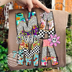 May include: A brown Halloween-themed sweatshirt with the word "MAMA" and "SPOOKY" in a colorful, patterned design. The design includes pumpkins, bats, and a skull flower. The word "ORIGINAL" is stamped on the bottom left.