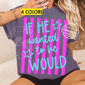 Peut inclure: T-shirt bleu-gris &agrave; manches courtes avec le texte "IF HE wanted to he WOULD" en turquoise et rose. Le motif comprend des rayures roses verticales et des &eacute;toiles. Le t-shirt porte &eacute;galement une &eacute;tiquette "4 COLORS".