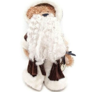 May include: A teddy bear dressed as Father Christmas, with a brown body, a white faux fur beard and hood, and brown velvet boots. The bear has a small blue nose and a tag attached to its arm.