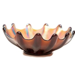 May include: A brown iridescent glass bowl with a scalloped rim. The bowl has a wide, shallow shape and sits on a small, round base. The interior of the bowl has a shimmering, colourful appearance.