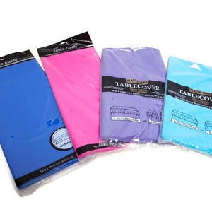 Puede incluir: Cuatro manteles de plástico en azul, rosa, morado y azul claro, cada uno empaquetado en plástico transparente. Las cubiertas azules y rosas son rectangulares. Las cubiertas moradas y azul claro están etiquetadas como "Plastic Lined Tablecover" y están diseñadas para mesas rectangulares y de cartas. Las cubiertas azules y rosas miden 137 x 274 cm.